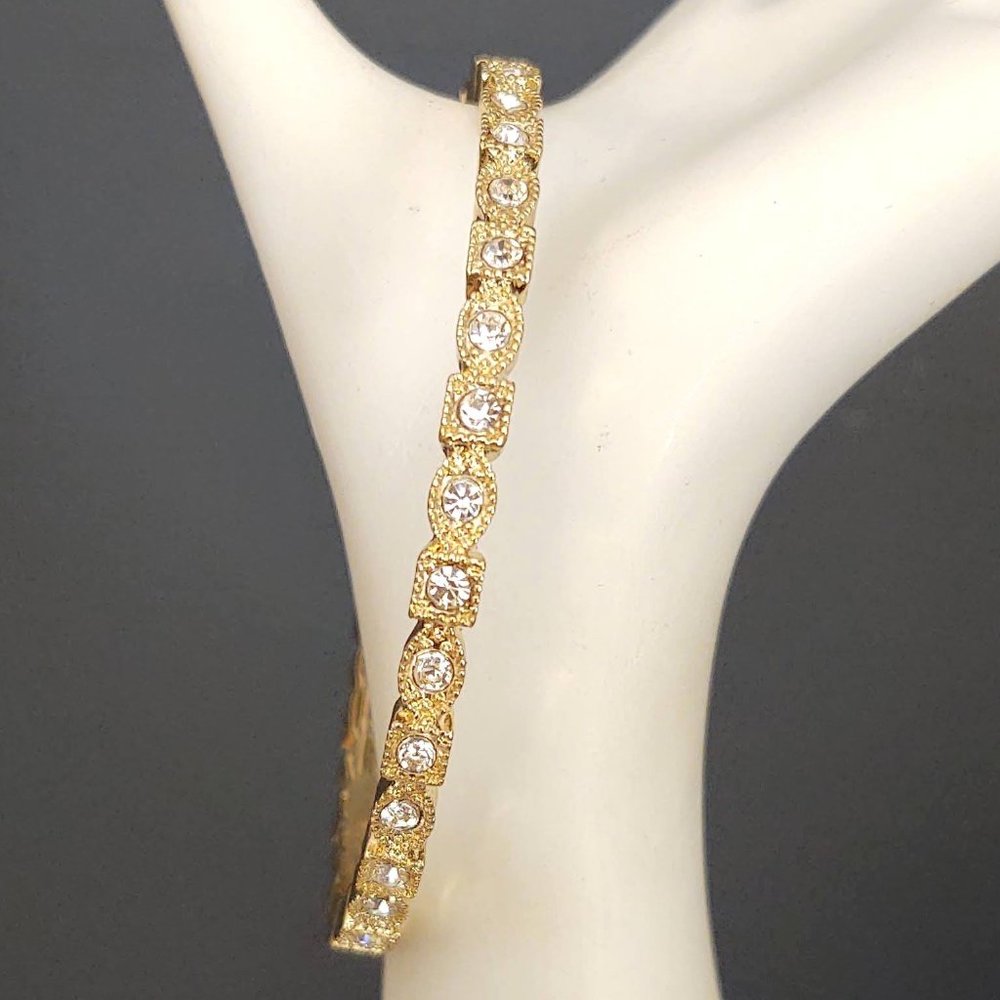 Gold bangle with square and oval design accented with clear cz